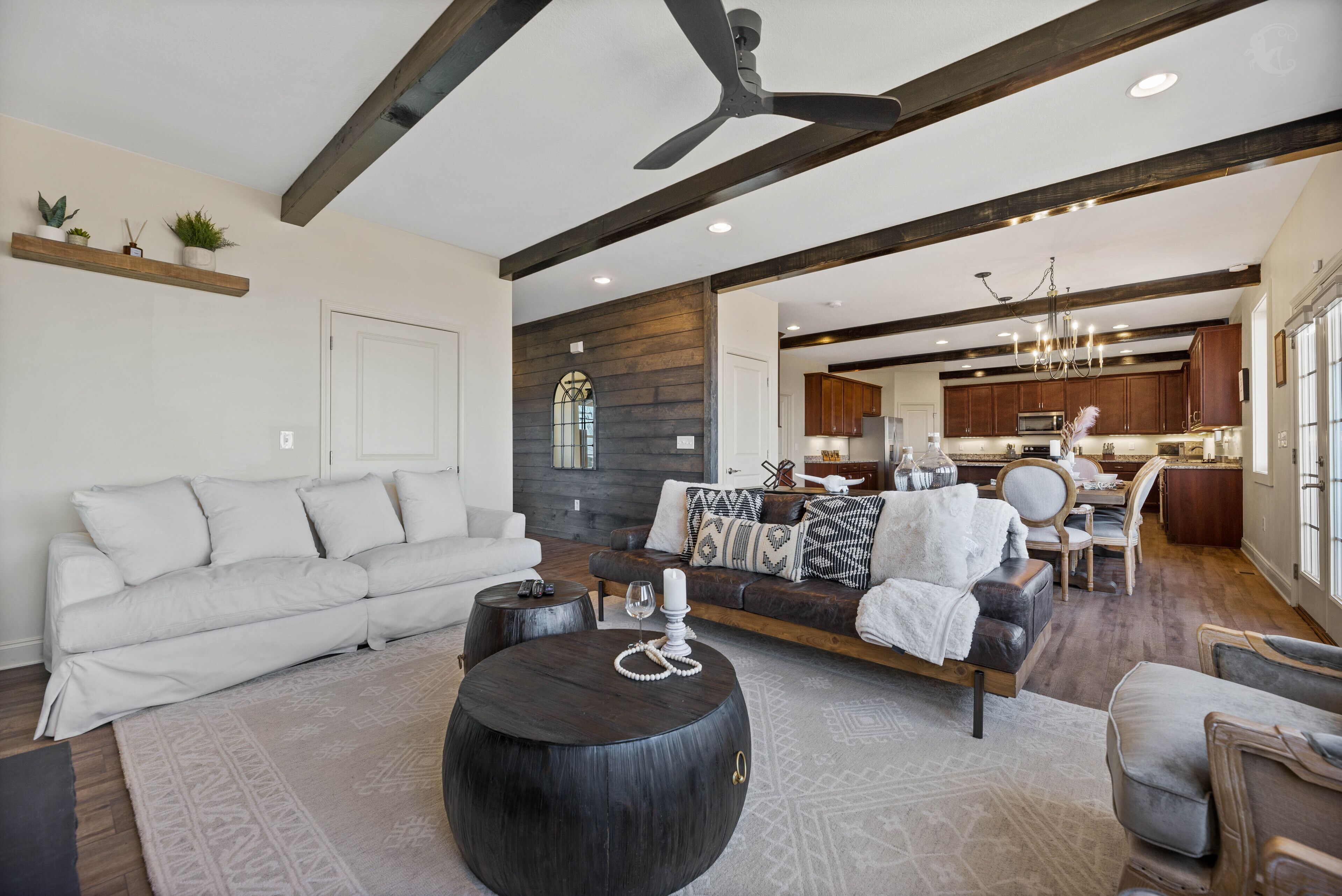 A spacious living room with a sofa, coffee table, and a dining area with chairs.