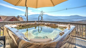 A hot tub on a deck with a mountain view.