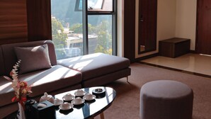 Un salon moderne avec un canapé, une table basse et une vue sur une montagne.