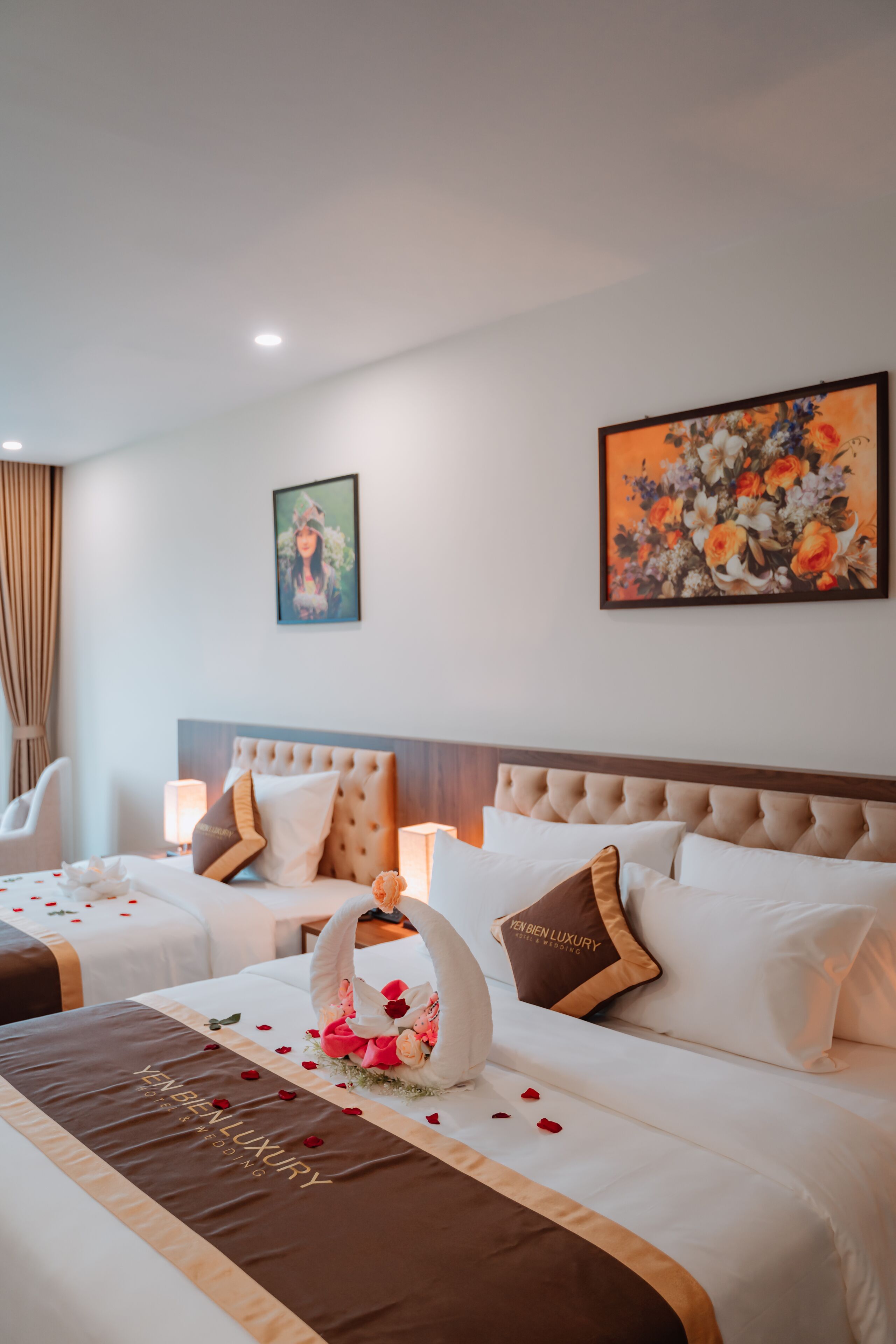 A hotel room with a large bed, a headboard, and a wall-mounted painting.