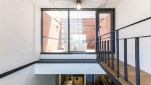 Um interior moderno com uma escada de vidro que leva a um andar superior.