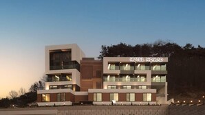 Um edifício de hotel moderno com vários andares, janelas amplas e uma placa com a inscrição "HOTEL NOMAD".