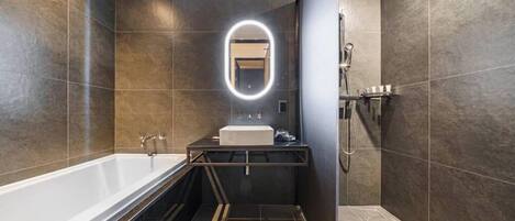 A modern bathroom with a bathtub, a sink, and a shower area.