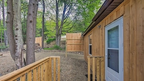 A wooden cabin with a deck and a door.
