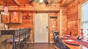 Un intérieur en bois comprenant un coin repas, une porte blanche et une décoration en forme d’étoile sur le mur.