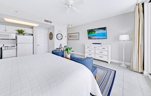 Une chambre moderne avec un grand lit, un bureau, une commode et un téléviseur.