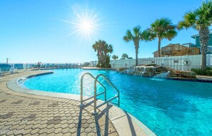 Relax by the pool surrounded by lush palm trees and a serene atmosphere.