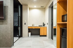 Una cocina moderna con horno empotrado, cafetera y cubo de basura.