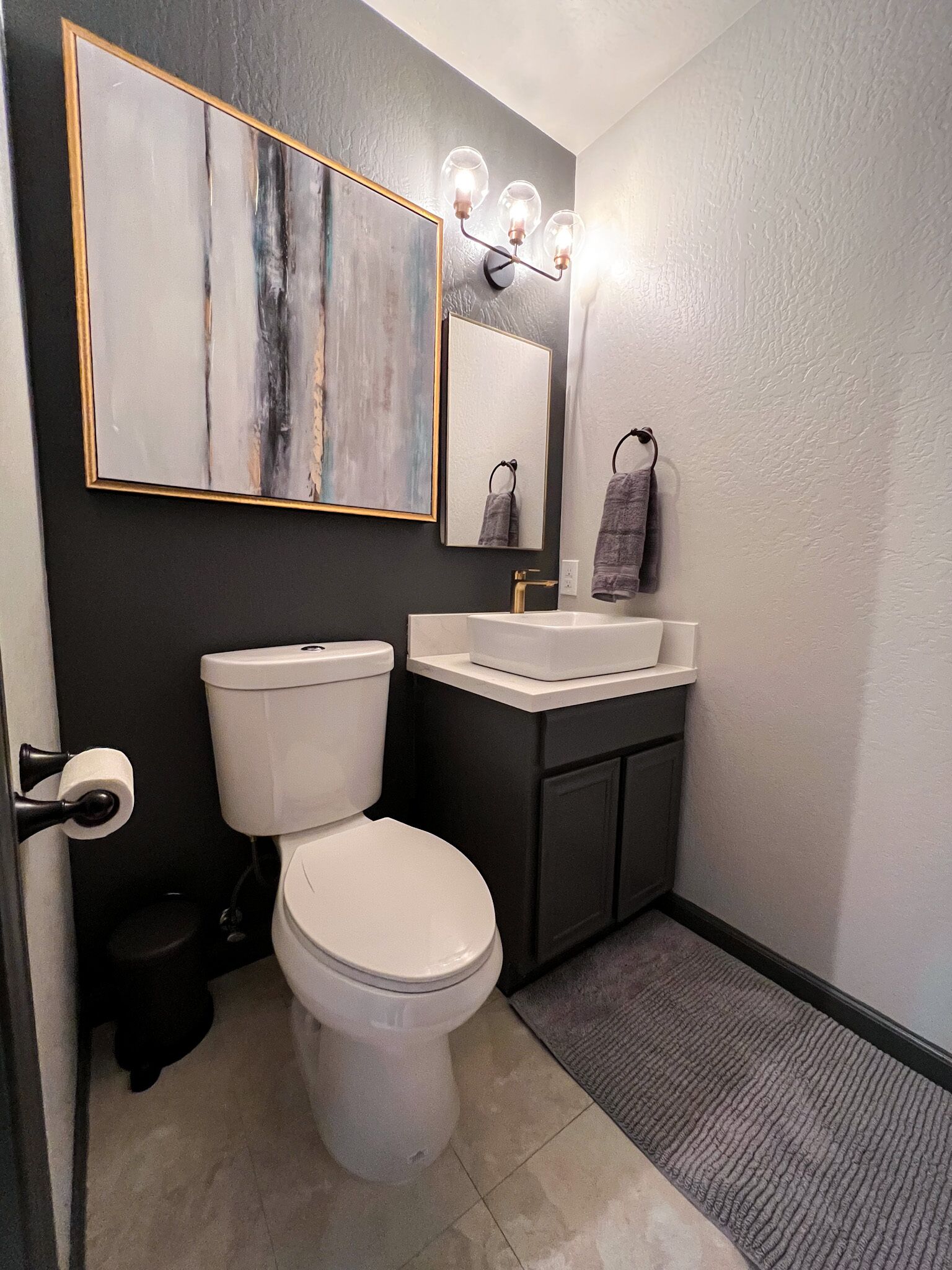 Een badkamer met toilet, wastafel en spiegel.