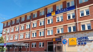 A multi-story hotel building with a prominent "HOTEL" sign, multiple windows, and a clear sky. - Hotel Marqués de Aguilar (Aguilar de Campoo)