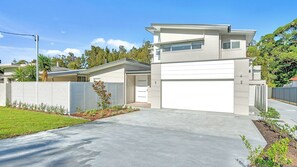 A modern two-story house with a garage, a covered driveway, and a fenced yard. - Ilanga Jervis Bay-Heated Pool (Huskisson)