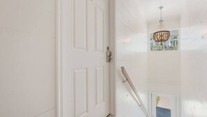 A white door with a metal handle, a glass door with a metal handle, and a metal handrail.
