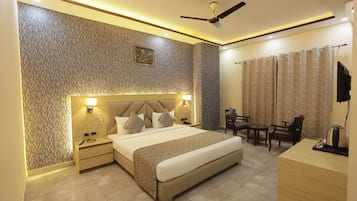 Une chambre d’hôtel moderne dotée d’un grand lit, de lampes de chevet, d’un bureau avec une chaise, d’un ventilateur de plafond et d’une télévision.