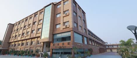 A multi-story building with a modern design, featuring a ground-level restaurant named "The Woodfire Kitchen."