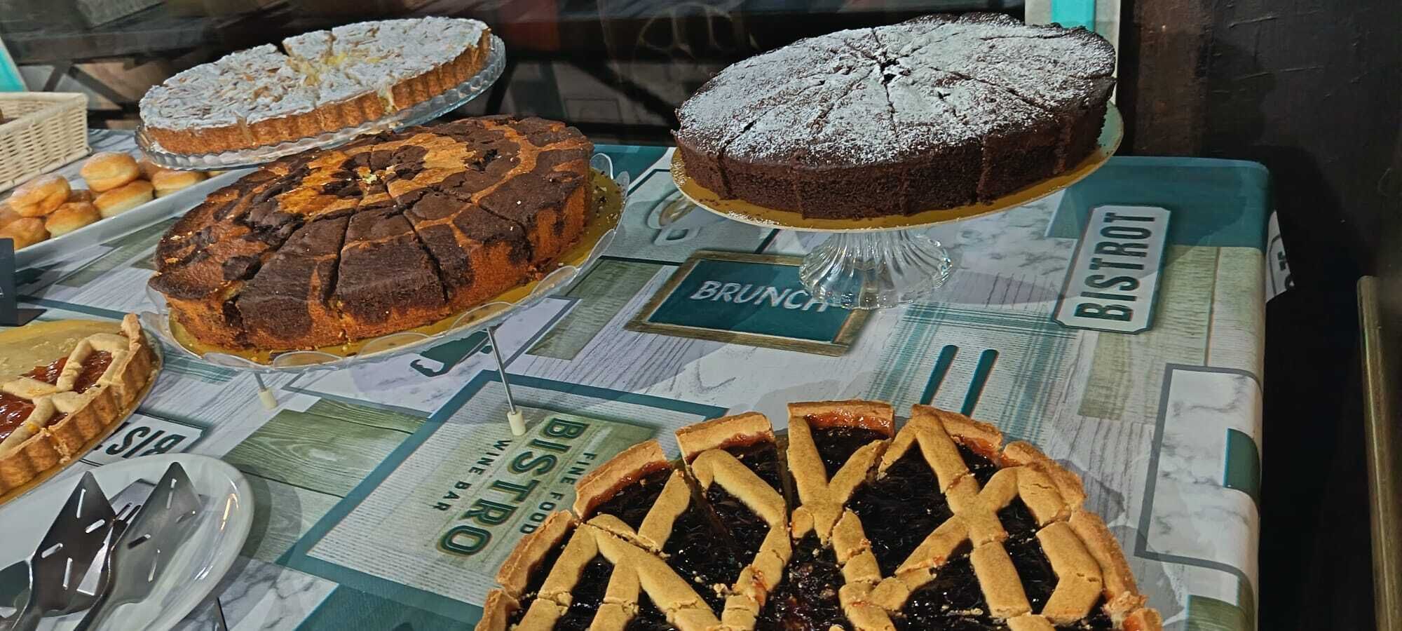 A variety of desserts on a table with a newspaper-style placemat.