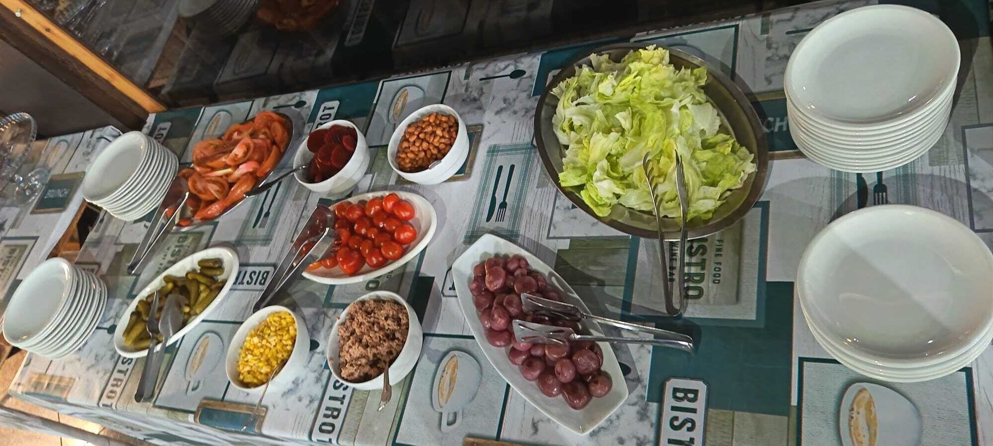 A buffet table with various dishes and utensils.