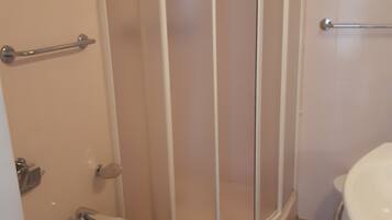 Un baño con cabina de ducha, un bidé y un lavamanos.