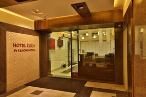 La entrada del HOTEL kablr por K & SONS HOTELS, con un diseño moderno, puertas de vidrio y una recepción visible.