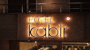 Ein Hotelausschild mit dem Namen "HOTEL kabir" und einem 'R'-Symbol.