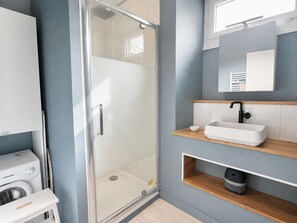 A modern bathroom with a glass shower enclosure, a white sink, and a mirror above the sink. - Evasion vue mer D-Day pontoons, quai Arromanches (Arromanches-les-Bains)