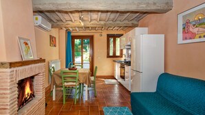Una cocina acogedora con chimenea, comedor y un sofá color turquesa.