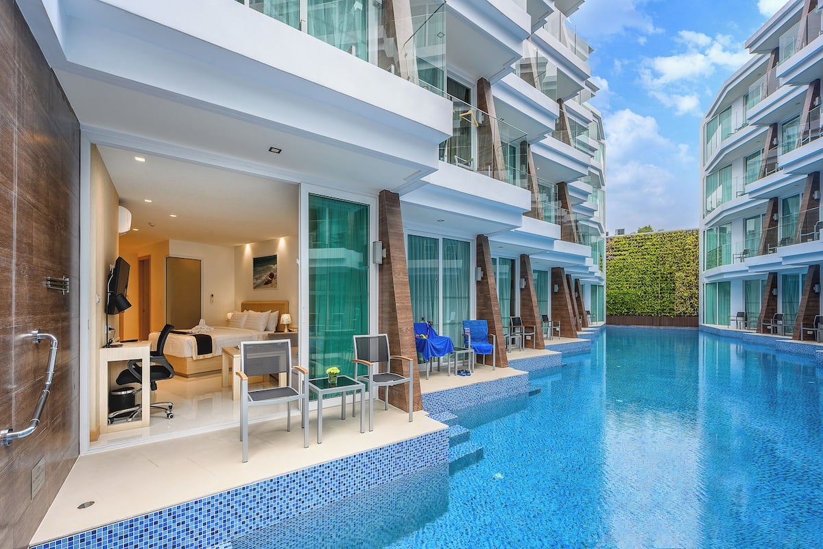A modern hotel with a pool area, including lounge chairs and a view of the pool.