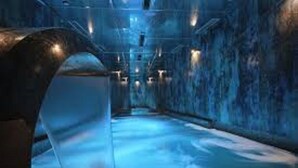 A corridor with a reflective floor and walls, illuminated by overhead lights. - Hotel Emirates (Sofia)