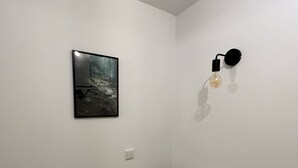 A room with a bed, a wall-mounted light fixture, and a framed picture. - Vacation apartment Kurpark Brilon on the Rothaarsteig Start (Brilon)