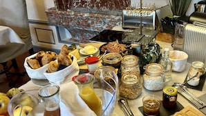 Un bufé de desayuno con diversas opciones de comida, incluyendo bollería, pan y salsas.