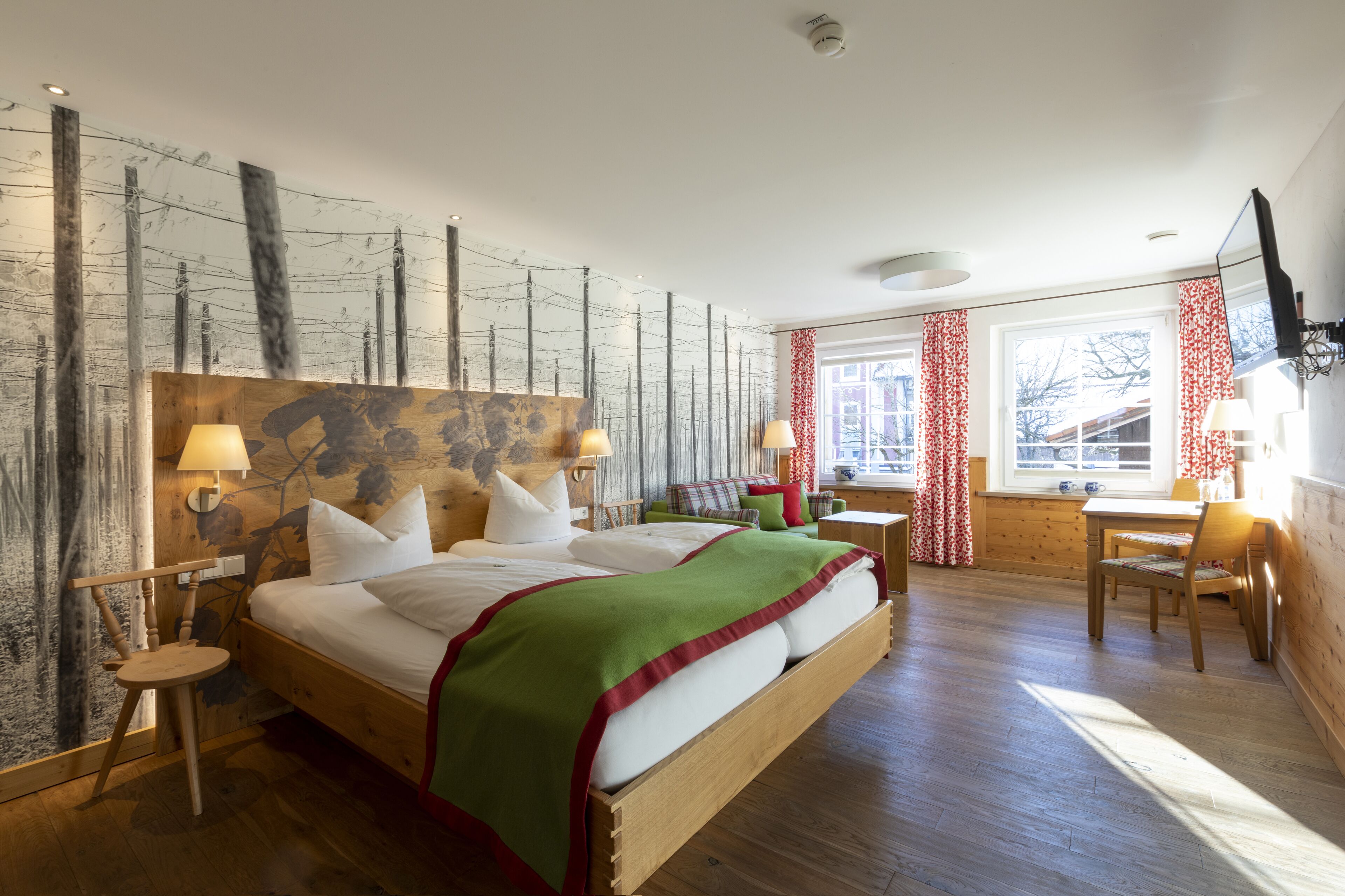 Une chambre d’hôtel avec un grand lit, une tête de lit en bois et une vue sur la ville par la fenêtre.