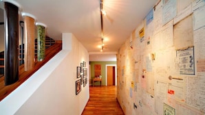 A hallway with wooden flooring, a staircase with metal railings, and walls covered with various papers and documents. - Brauereigasthof & Hotel Schäffler (Missen-Wilhams)