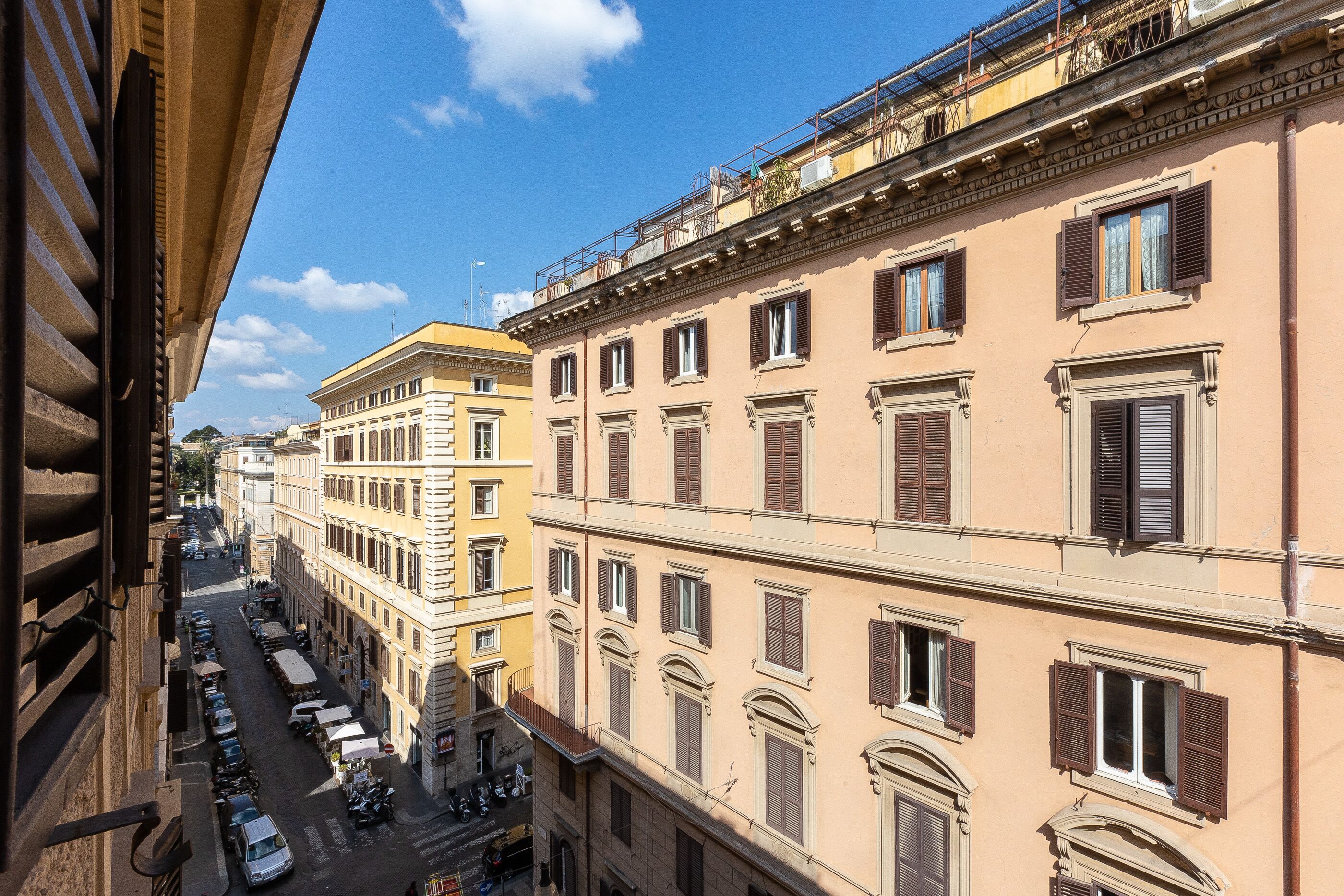 A street view of a historic building with multiple stories, large windows, and a balcony.