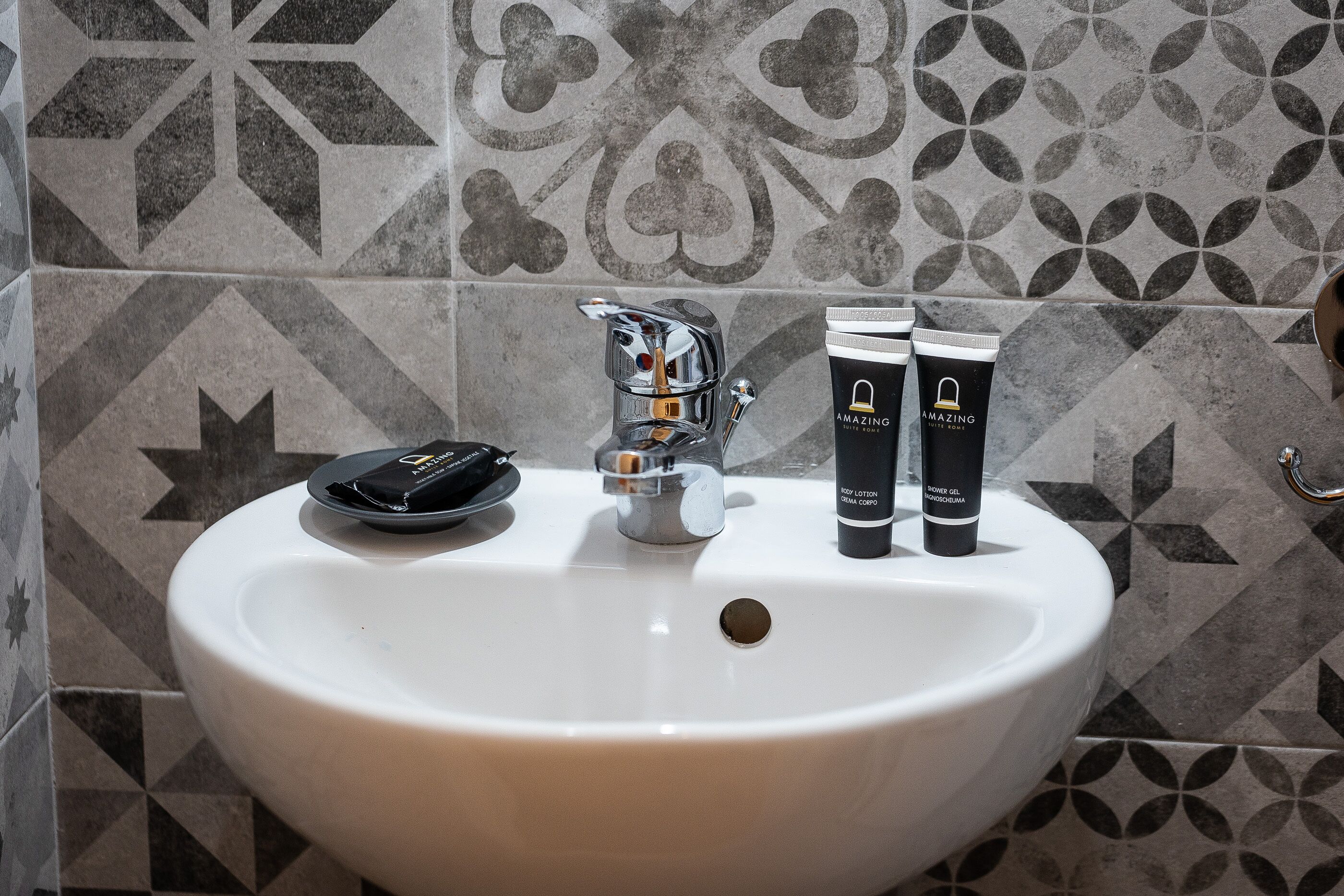 A bathroom sink with a modern faucet and two toiletries on the counter.