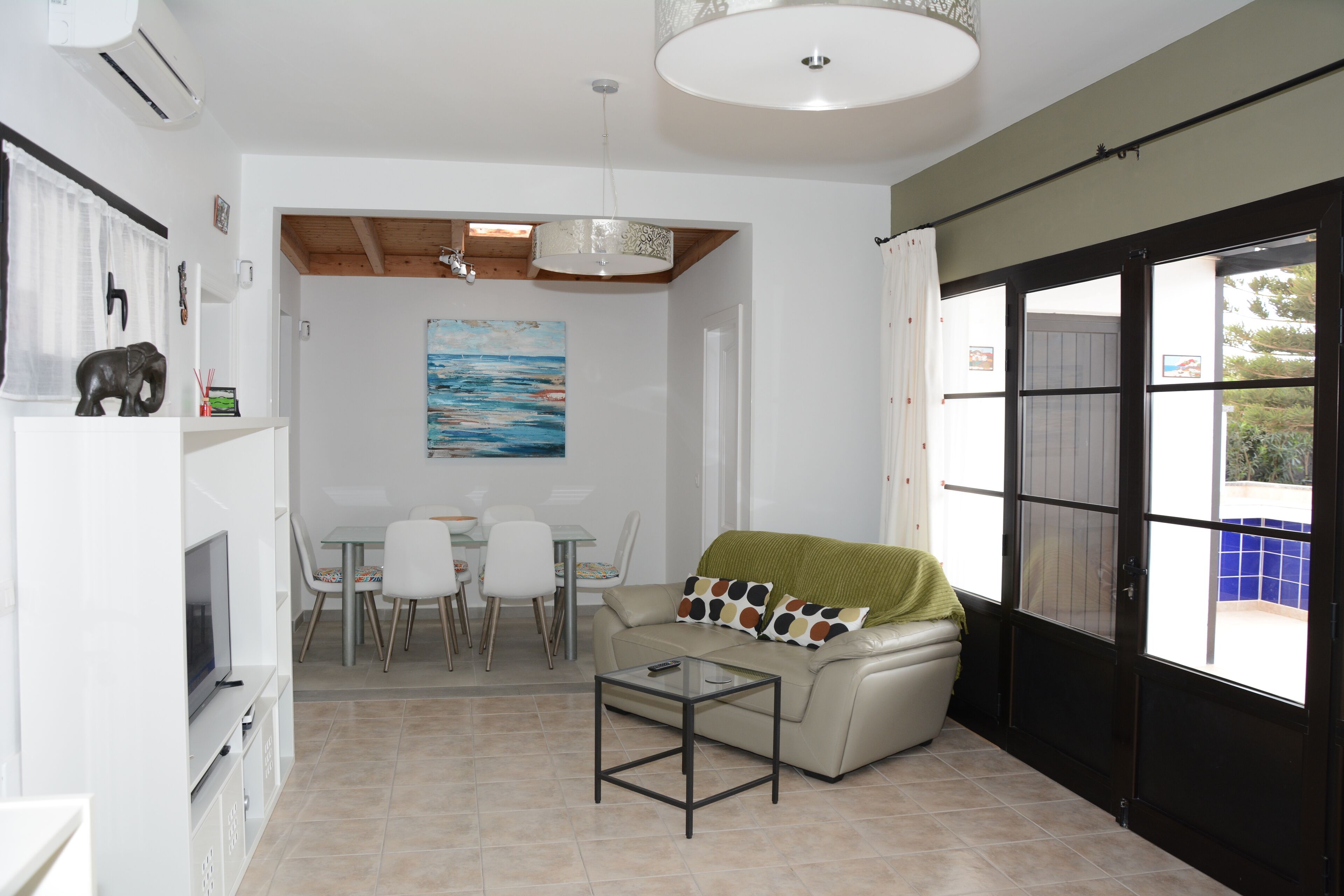 Una sala de estar moderna con sofá, mesa de centro y comedor.