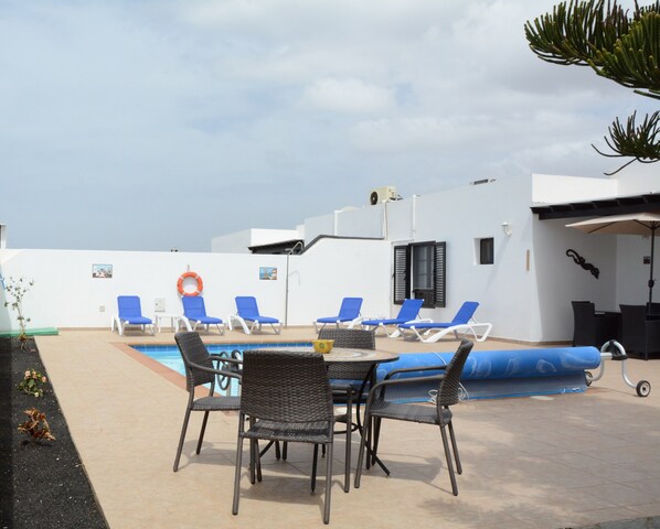 A rooftop pool area with lounge chairs and a dining table. - Villa julima 110 m2 3 ch AC everywhere wifi broadband, tv uk heated pool (Playa Blanca)