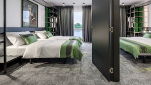 Une chambre d’hôtel moderne avec un grand lit, une armoire et une vue sur l’extérieur.