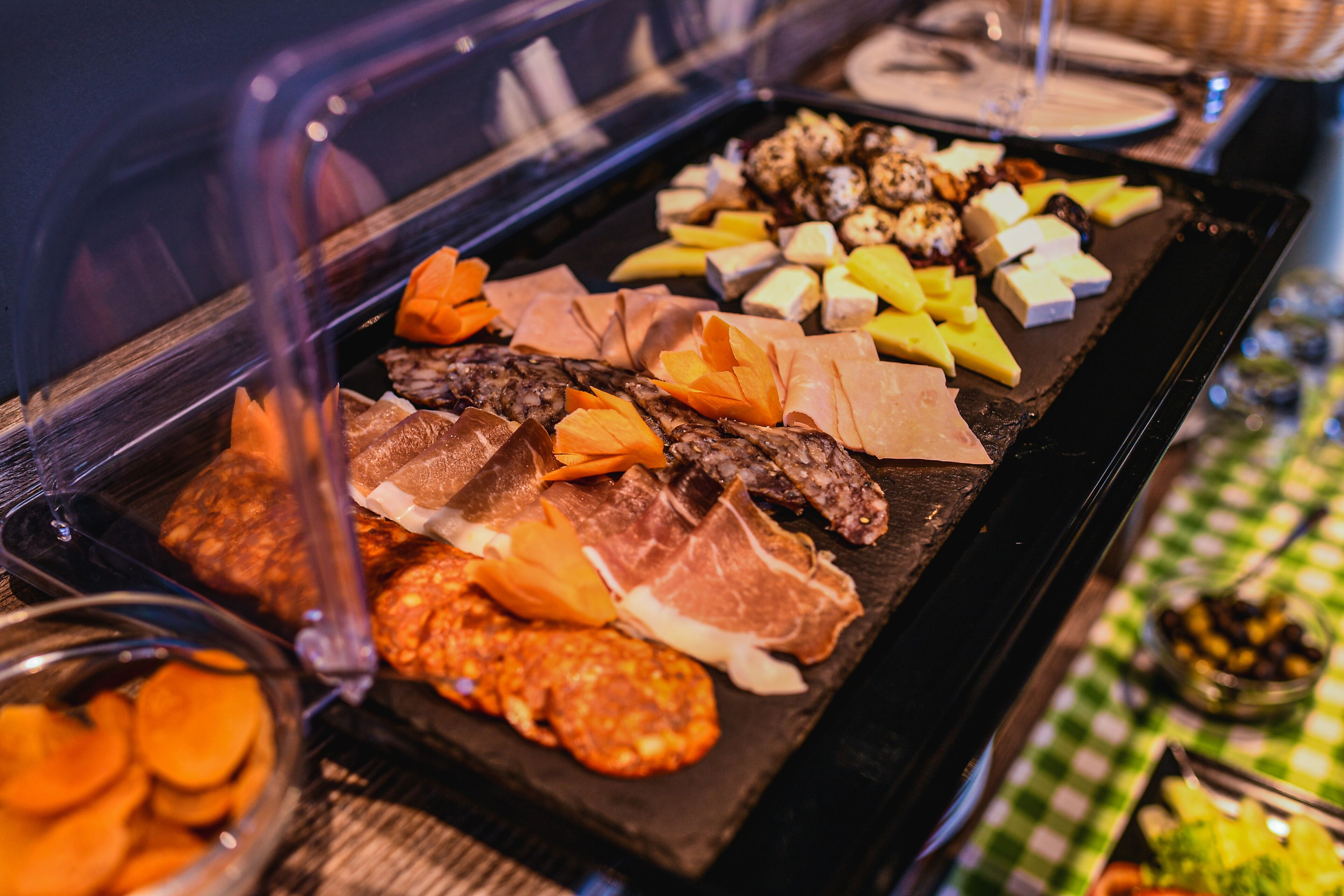Un buffet proposant une variété de viandes, de fromages et de fruits.