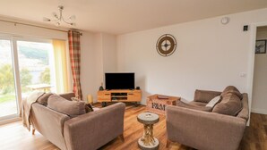 A living room with two sofas, a TV, and a wooden floor. - Lochy Lookout (Spean Bridge)