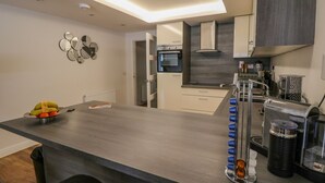 A modern kitchen with a central island, built-in appliances, and a minimalist design. - Lochy Lookout (Spean Bridge)