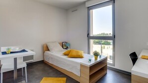 A modern, compact bedroom with a bed, a desk, and a large window. - Apparteo Toulouse (Toulouse)