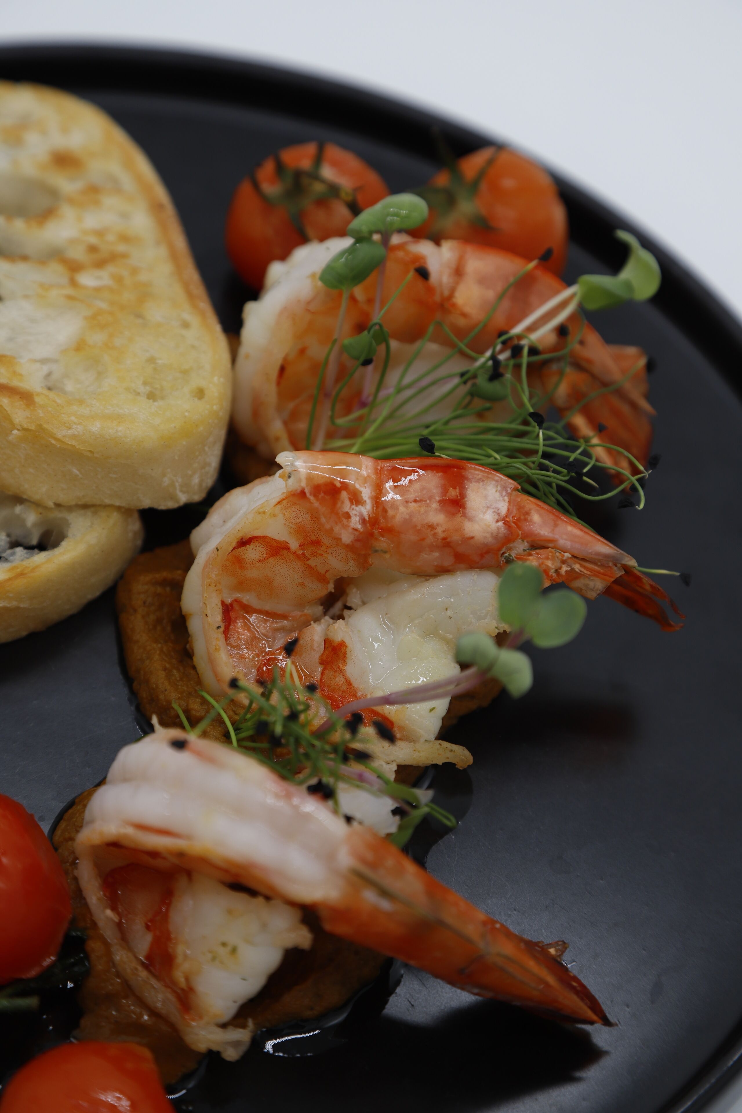 Un plato de comida con camarones y tomates.