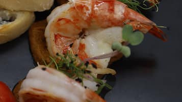Un plato de comida con camarones y tomates.