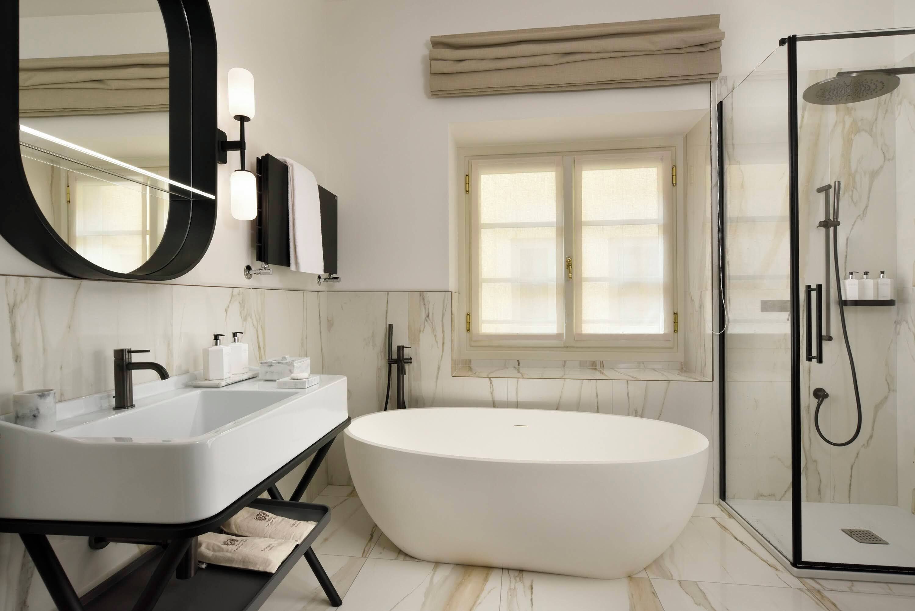 Ein modernes Badezimmer mit freistehender Badewanne, einem großen Spiegel und einer Duschkabine.