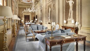 Een luxueuze hotel lobby met weelderige kroonluchters, klassieke beelden en stijlvol meubilair.