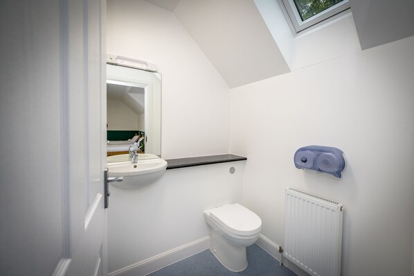 A small, modern bathroom with a toilet, sink, and a radiator.