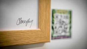 A framed artwork with the name "Clonaghy" and a QR code on the wall.