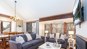 A modern living room with two grey sofas, a white coffee table, and a fireplace.