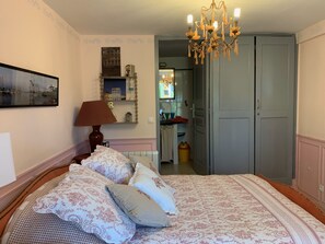 Une chambre à coucher avec un lit, une lampe, un lustre, un miroir et une armoire.