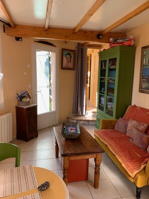 Un salon chaleureux avec un banc en bois, un meuble vert et un canapé rouge.