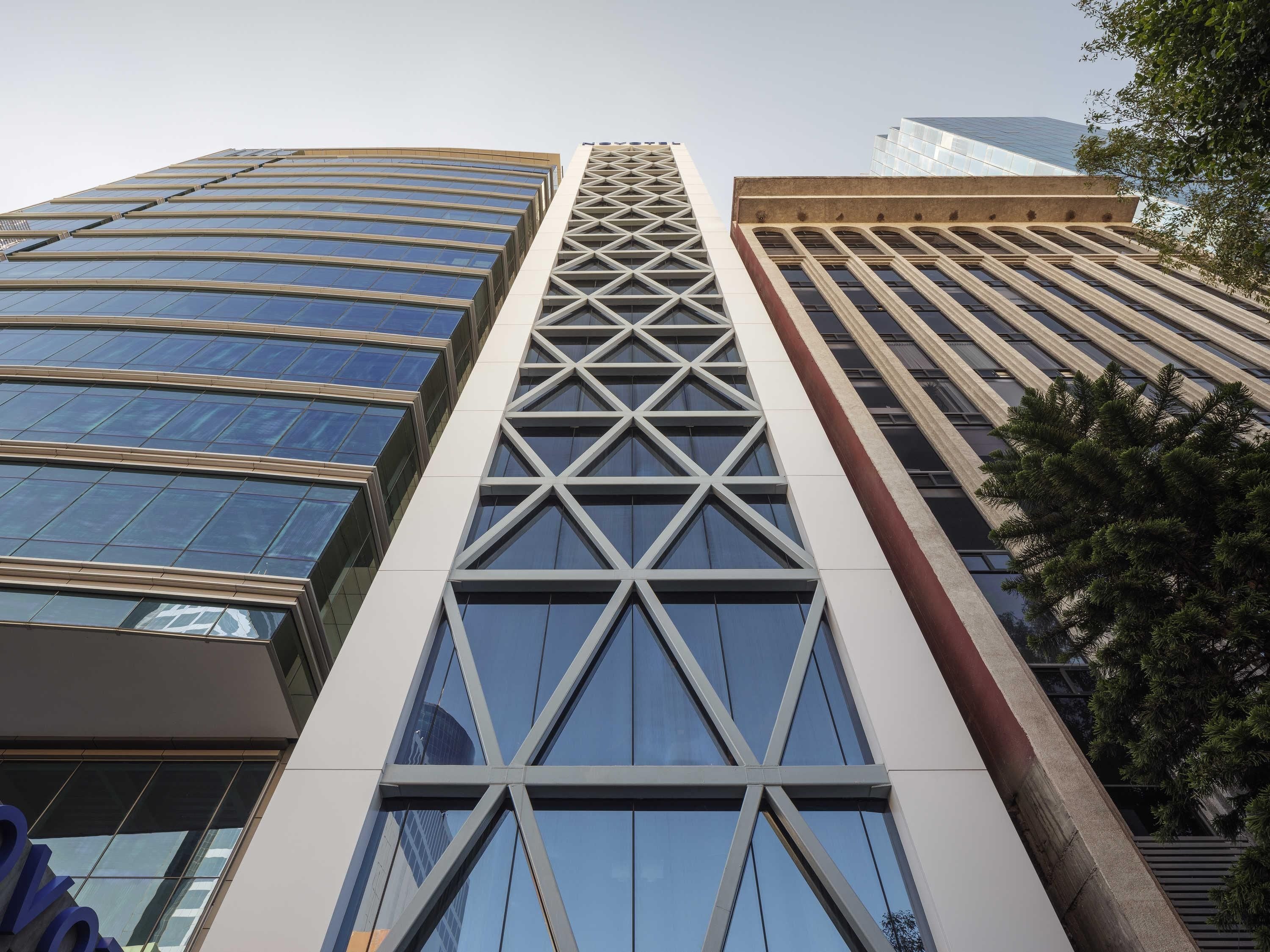 A modern high-rise building with a distinctive geometric facade, large windows, and a prominent central tower.